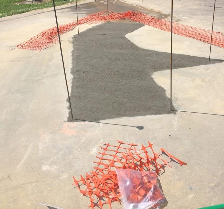 Fresh concrete patch at a commercial entrance
