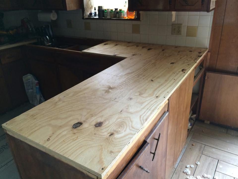New plywood countertop base installed on kitchen cabinets
